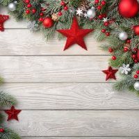 Christmas background with bright wooden board and fir branches decorated with red and silver baubles and stars - modern, simple and elegant